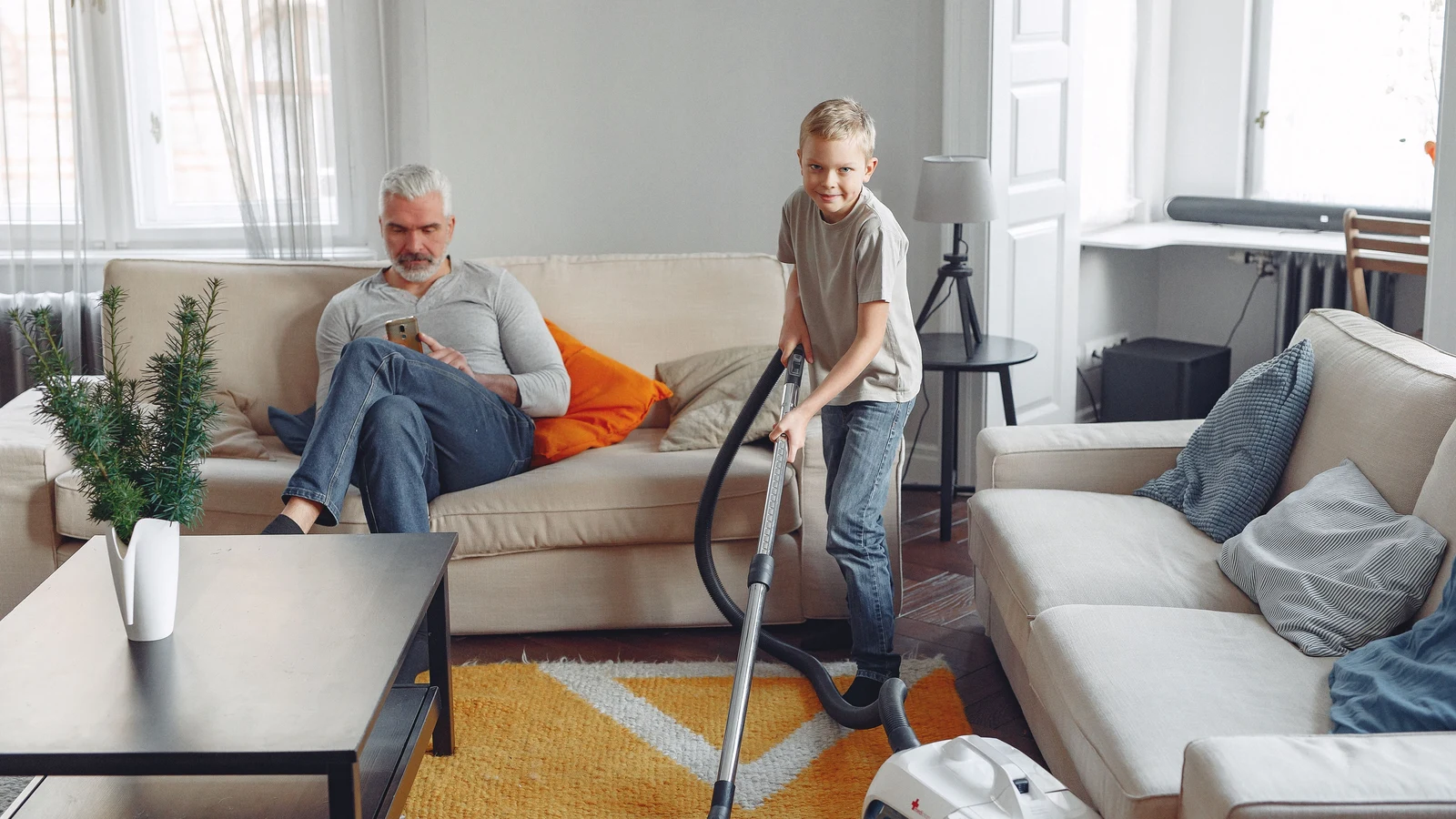 Aide ménagère passant l'aspirateur au domicile d'un senior